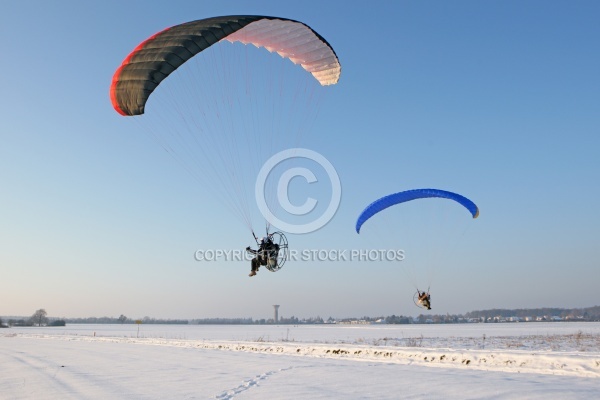 Paramoteur volant en hiver dans les champs enneigés de la régi