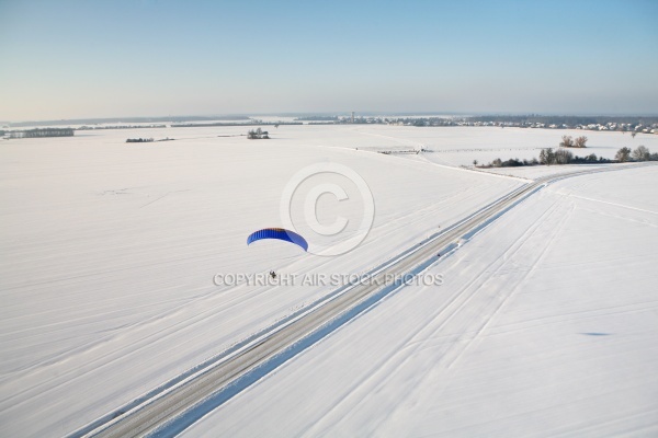 Vue aérienne du paramoteur survolant une route en hiver dans le