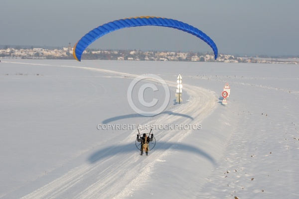 Aerial view of paramotor following a road in winter in France