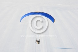 Fond de paysage de neige blanche survolé par un paramoteur