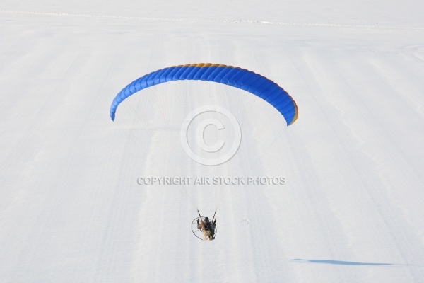 Fond de paysage de neige blanche survolé par un paramoteur