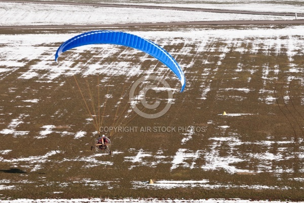Motorized paraglider or paramotor preparing to land on a light a