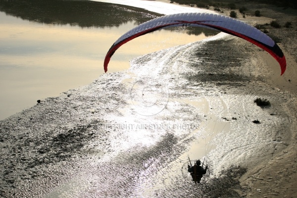 Paramoteur en contre jour survolant la plage , Vendée 85