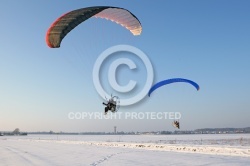 Paramoteur volant en hiver dans les champs enneigés de la régi