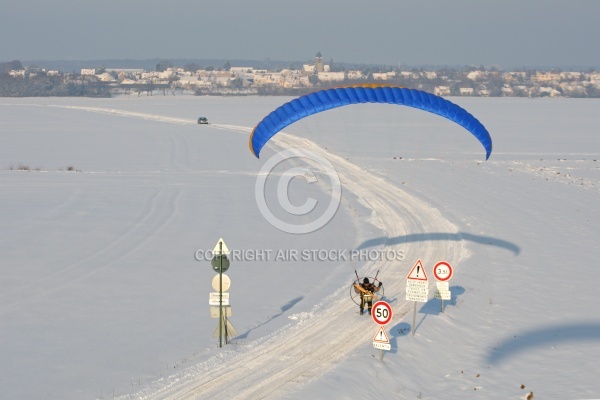 Vue aérienne d un paramoteur survolant une route enneigée avec