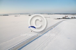 Vue aérienne du paramoteur survolant une route en hiver dans le