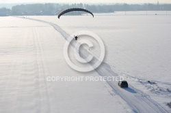 Vue aérienne du parapente motorisé survolant une route enneig
